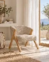 Generated with Kive.ai - crear una imagen de esta butaca cerca de una ventana bonita con cortinas blancas_ minimalista y un pequeño toque mediterraneo Upholstered wooden chair.webp