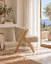 Generated with Kive.ai - Upholstered wooden chair Create a new photograph of this same chair in the same Mediterranean room. Camera move 90° around to the side of the chair_ keeping the same camera height and dista.webp